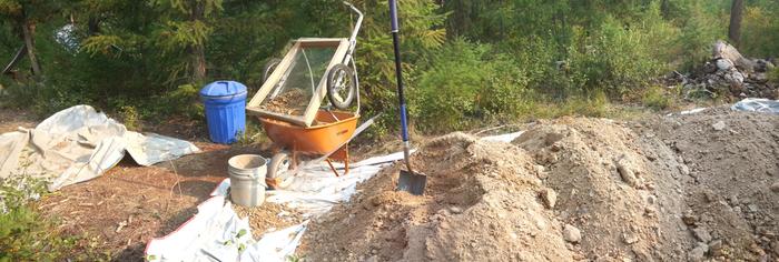 from left to right: stomping station, barrel for soaking cow pies, sifting station, pile of dirt, pile of cow pies