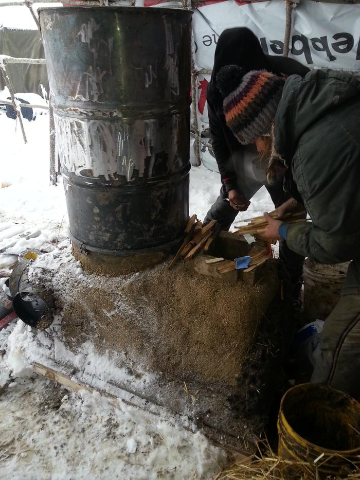 Jesse working on a rocket mass heater in the roundwood school