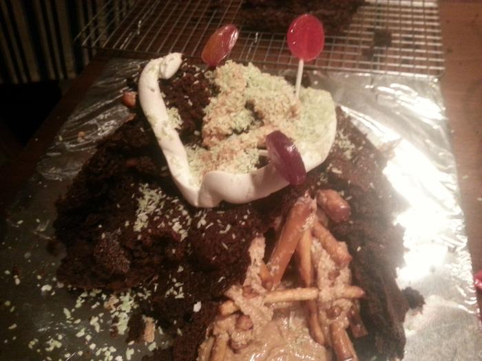 partially collapsed gingerbread wofati with lollipop trees growing out of the roof