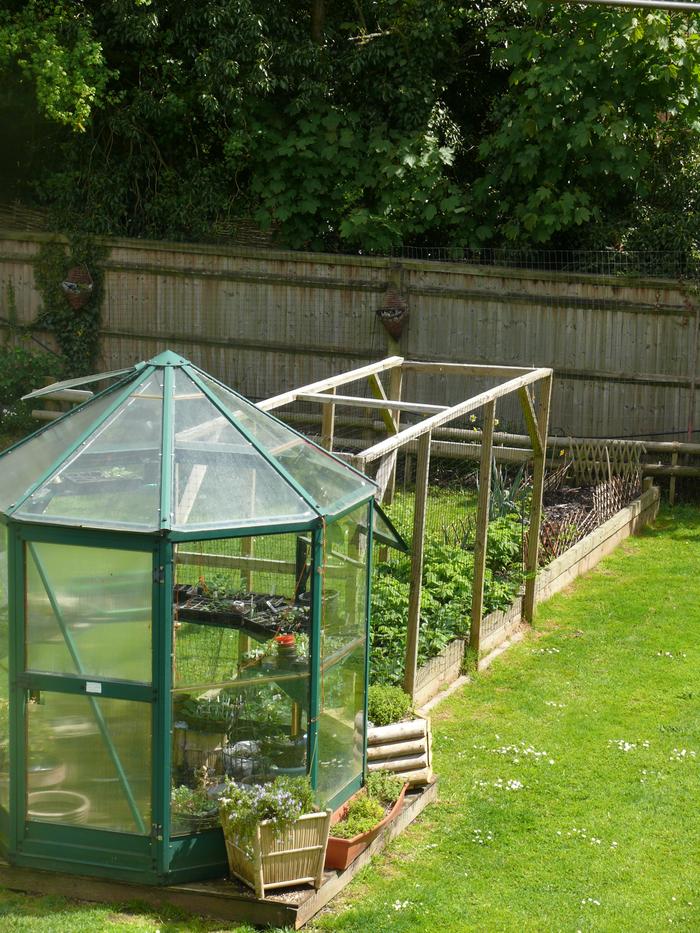 Salvaged greenhouse, salvaged logs for flower feature, salvaged bricks , pots etc