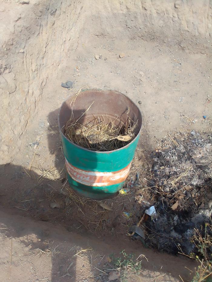 soil, grass and ash close to the pit corner for banana tree