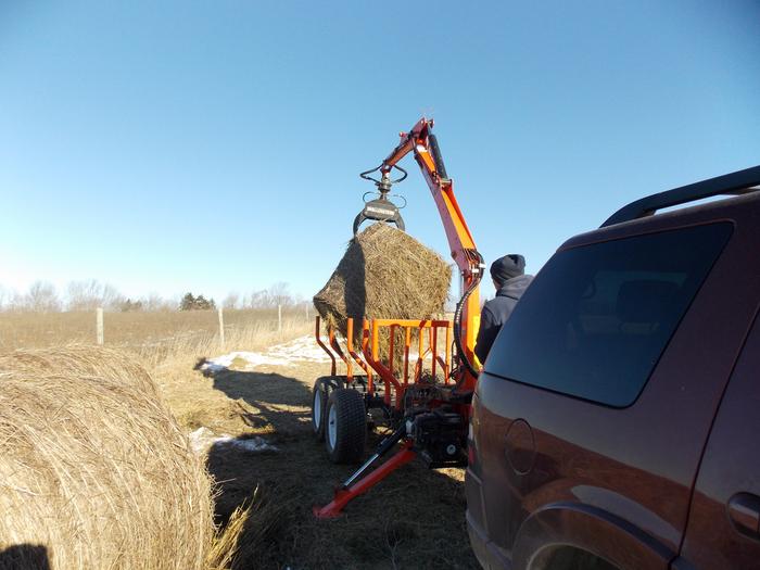 Wallenstein Trailer picking up hay bale