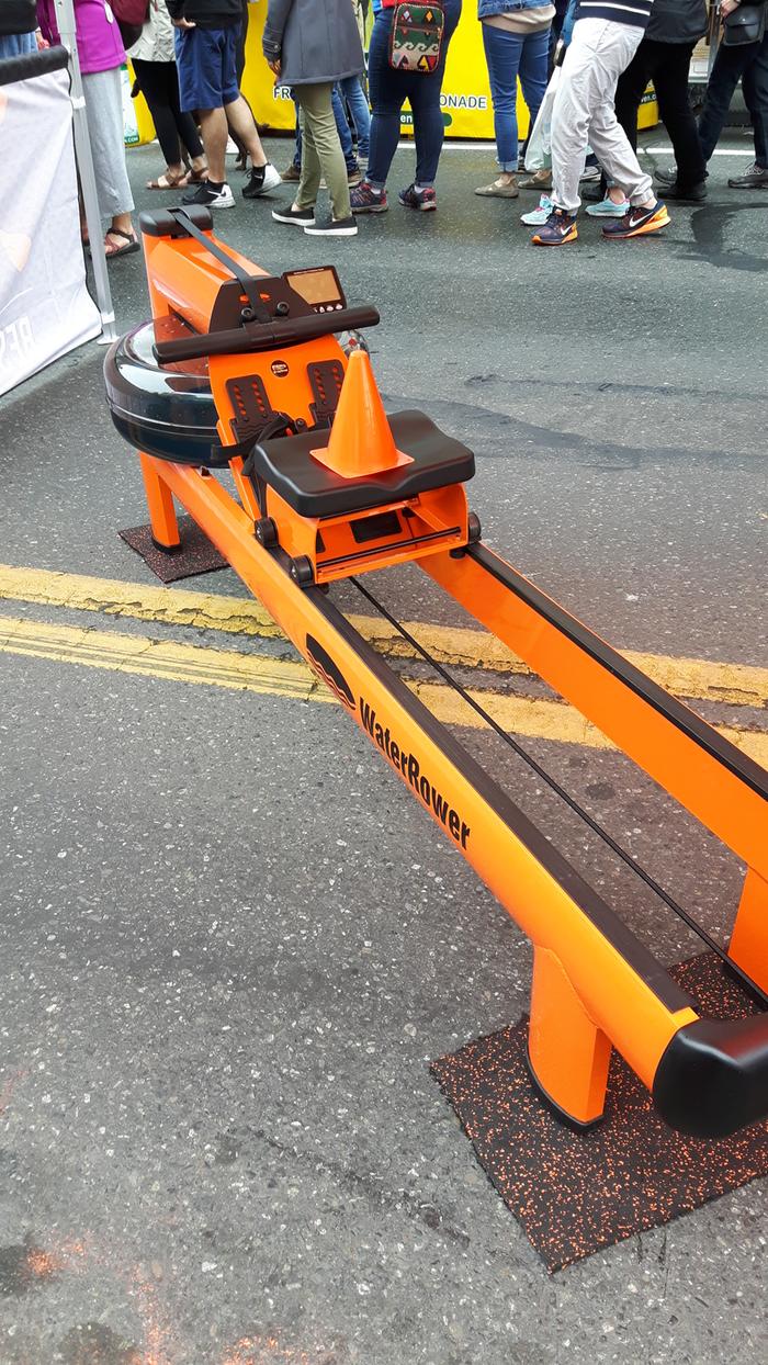 An orange exercise rowing machine that uses water as the damper