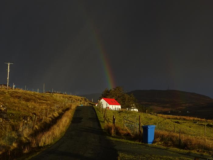 Rainbow over red roof Isle of Skye