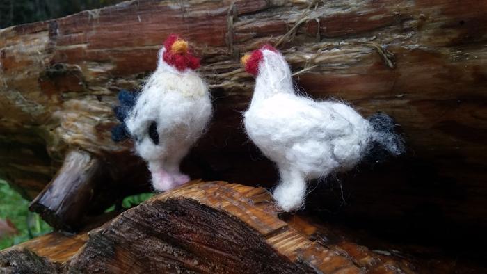 white wool hen and rooster pair on log bench