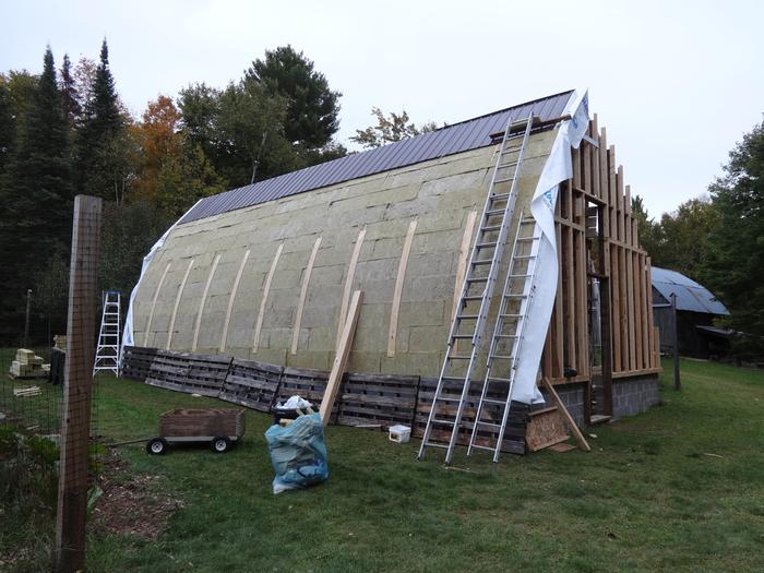 Rockwool going up on the north side. Bent wood straps to attach metal to. Gutter screws were the perfect length to attach them to the trusses