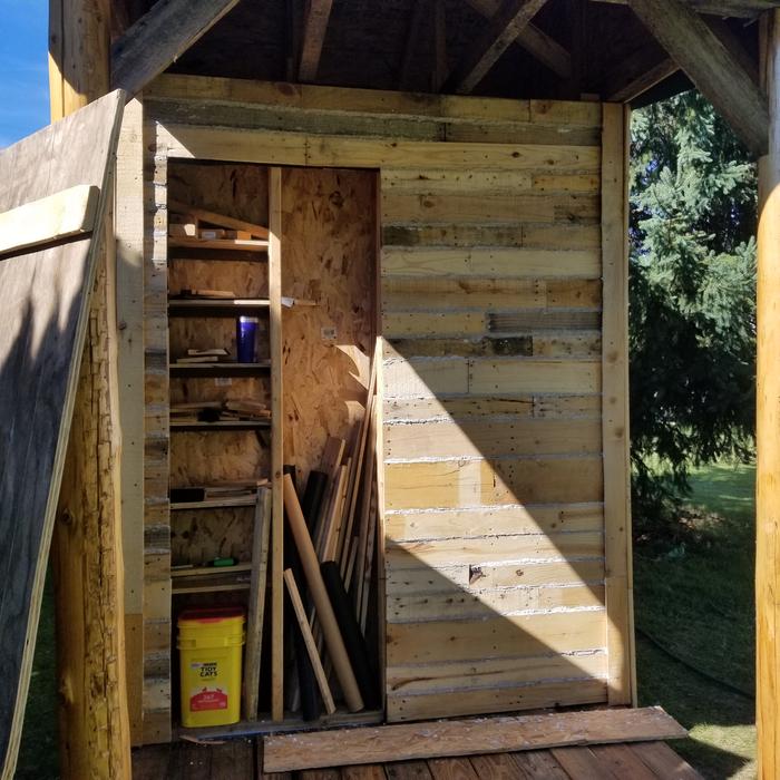 inside the closet, half shelves and half shovels