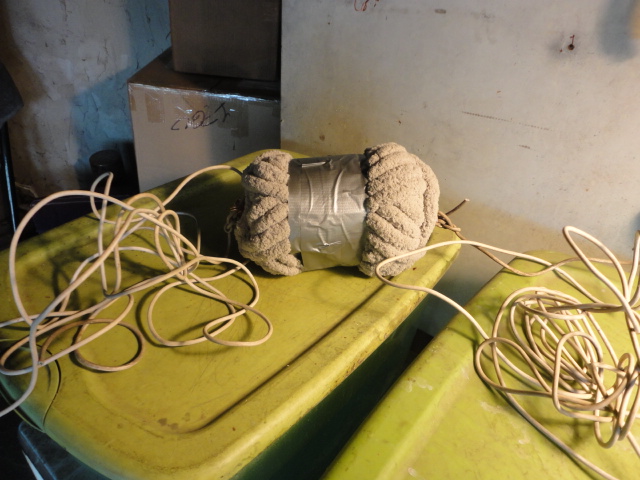 The tool with the duct tape wrapped around the middle and ropes attached to each end.