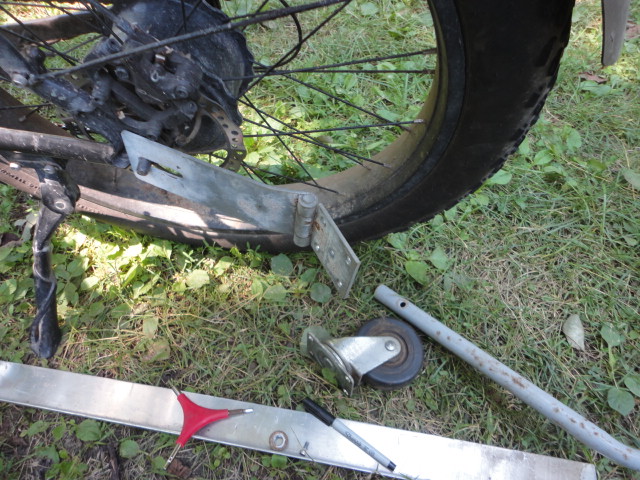 The parts to make the connecting hitch for the bike. I'm measuring out where I need to drill holes.