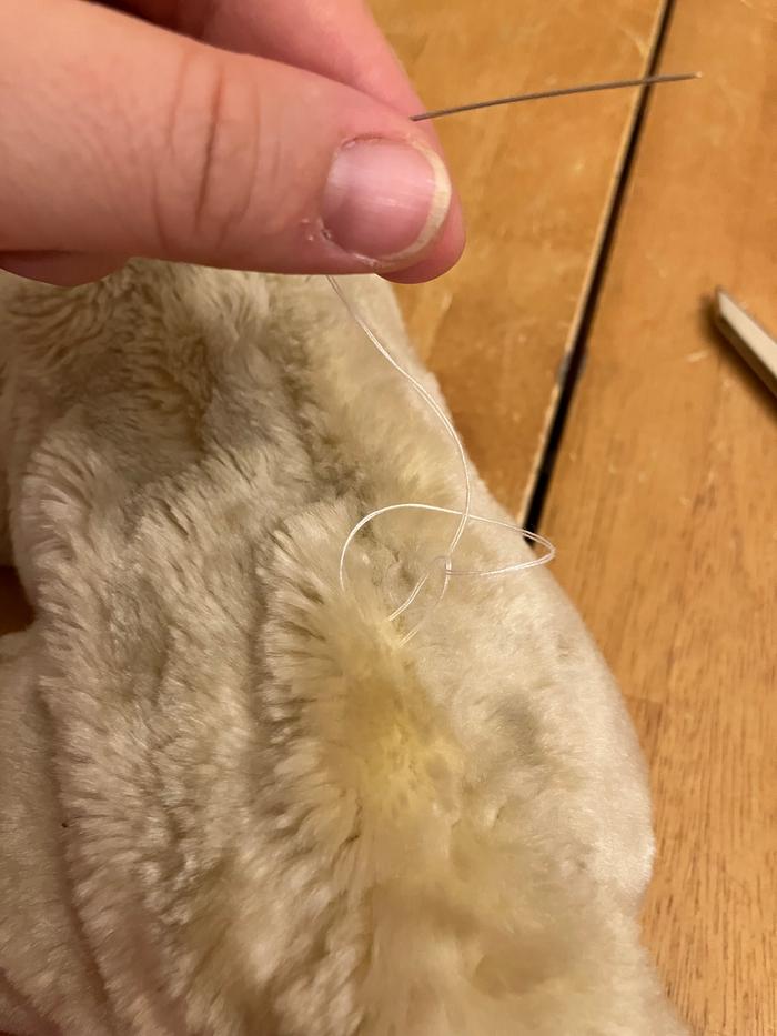 Tying a knot. I believe this is called a French knot.