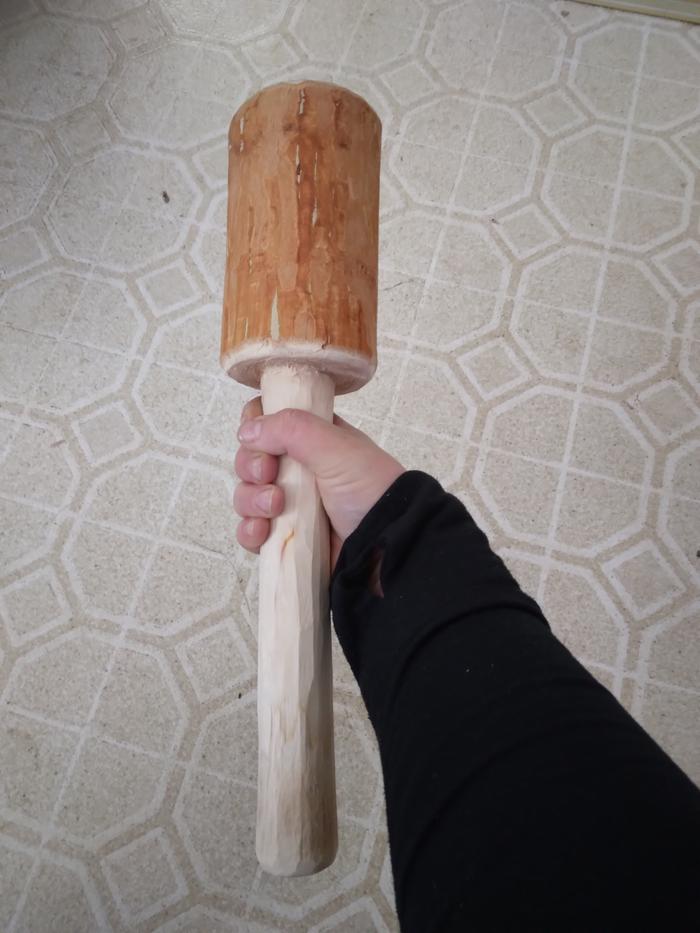 The finished mallet in my hand with chamfers and knife smooth handle