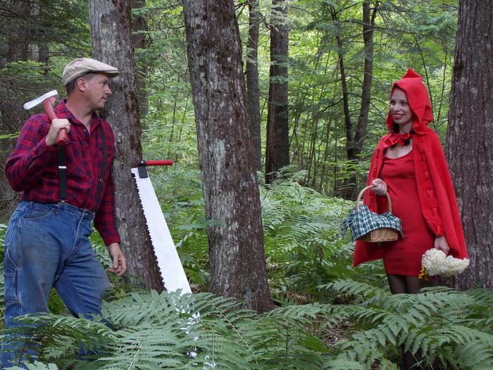 the woodsman with his axe and saw saving little red riding hood with her basket and flowers